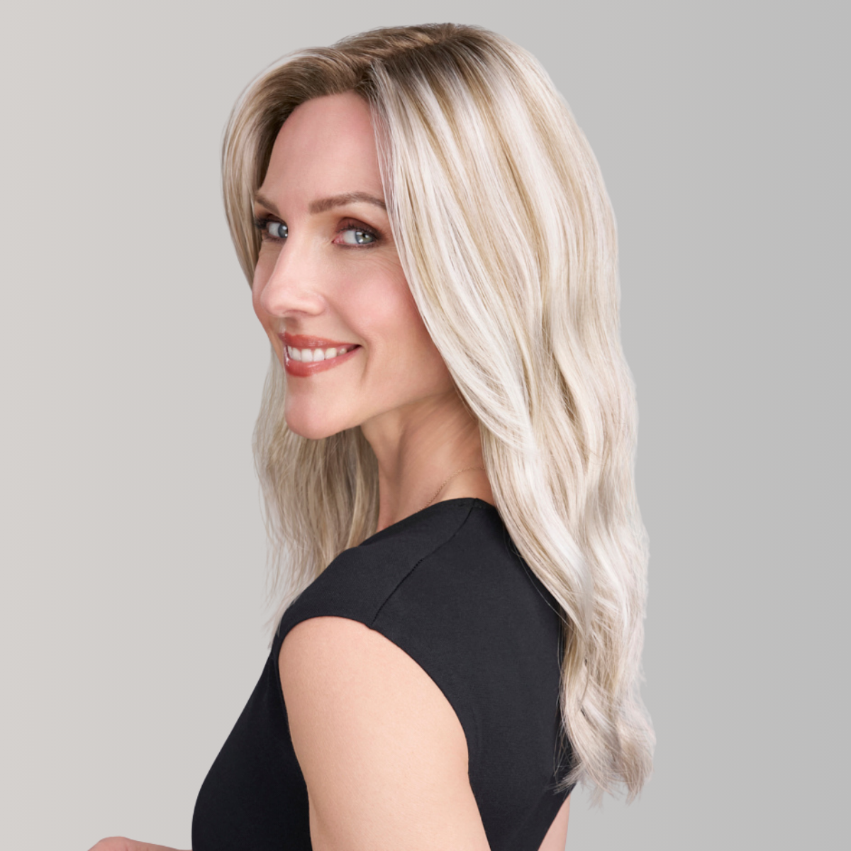 Woman with styled blonde hair against a gray background