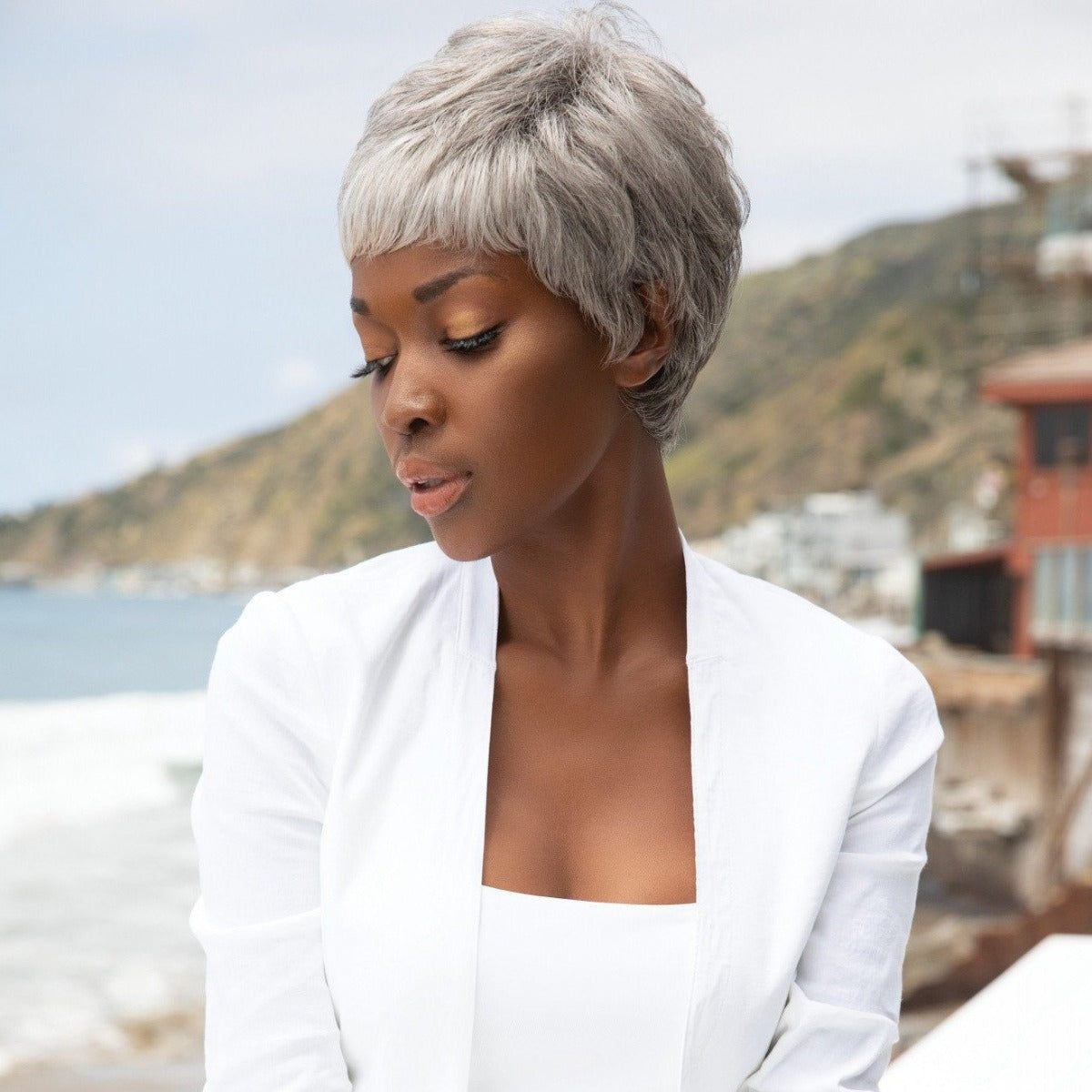 Short-length synthetic wig. This straight ready-to-wear wig is a fashion forward pixie with tapered nape. Gabby is machine made with adjustable tabs in the back nape area to allow a more comfortable fit. The result is a comfortable fit with a natural look that is both fashionable and easy to wear. Shown in Silver Stone